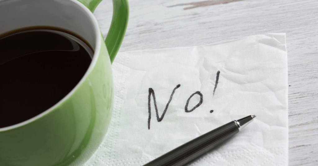 word no written on napkin with green mug of coffee